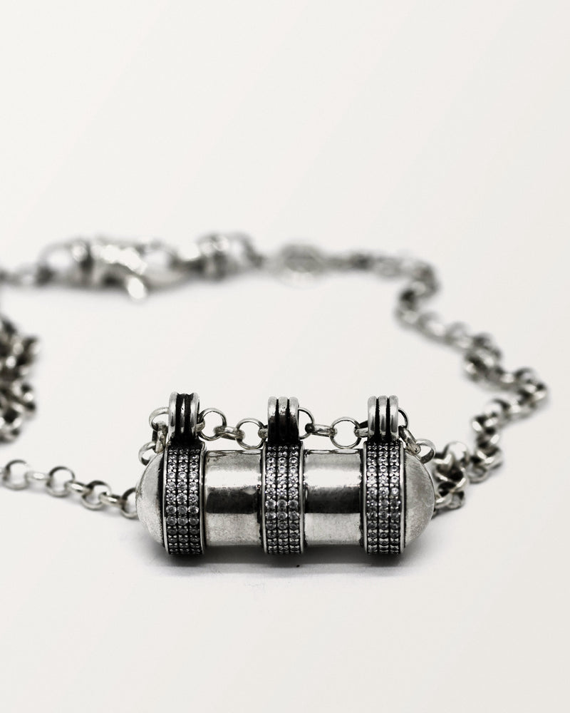 Agraja amulet necklace in sterling silver, closed, laid flat on white.