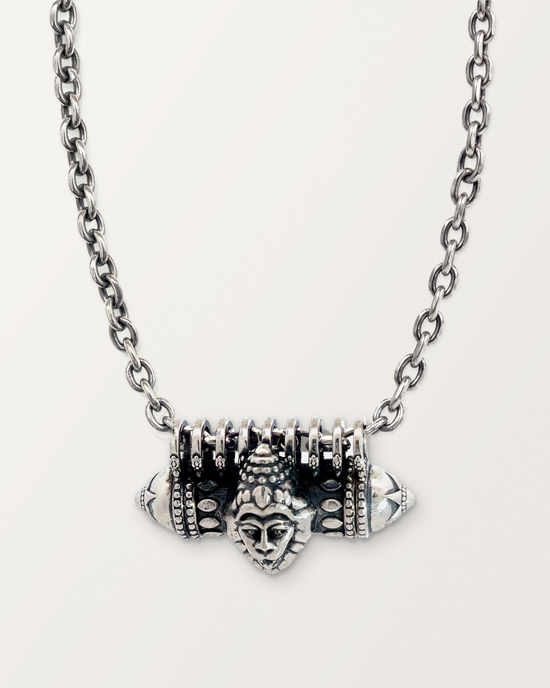 Sterling silver Narashimha amulet necklace, closed, on its heavy oval cable chain against a warm bone-white background.