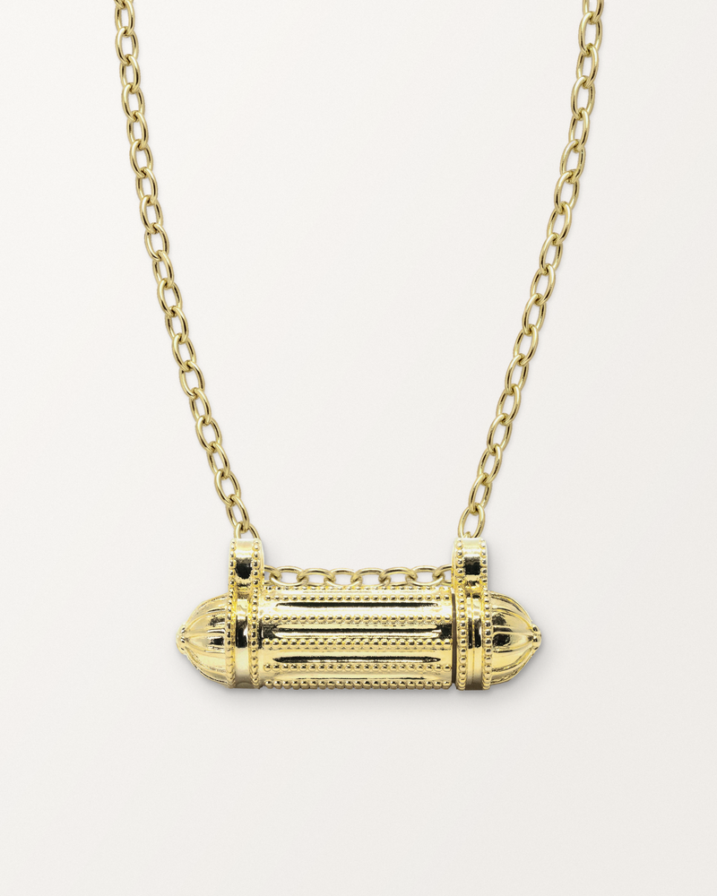Taweez openable amulet necklace in 14K or 18K yellow gold, closed, on a warm bone-white background.