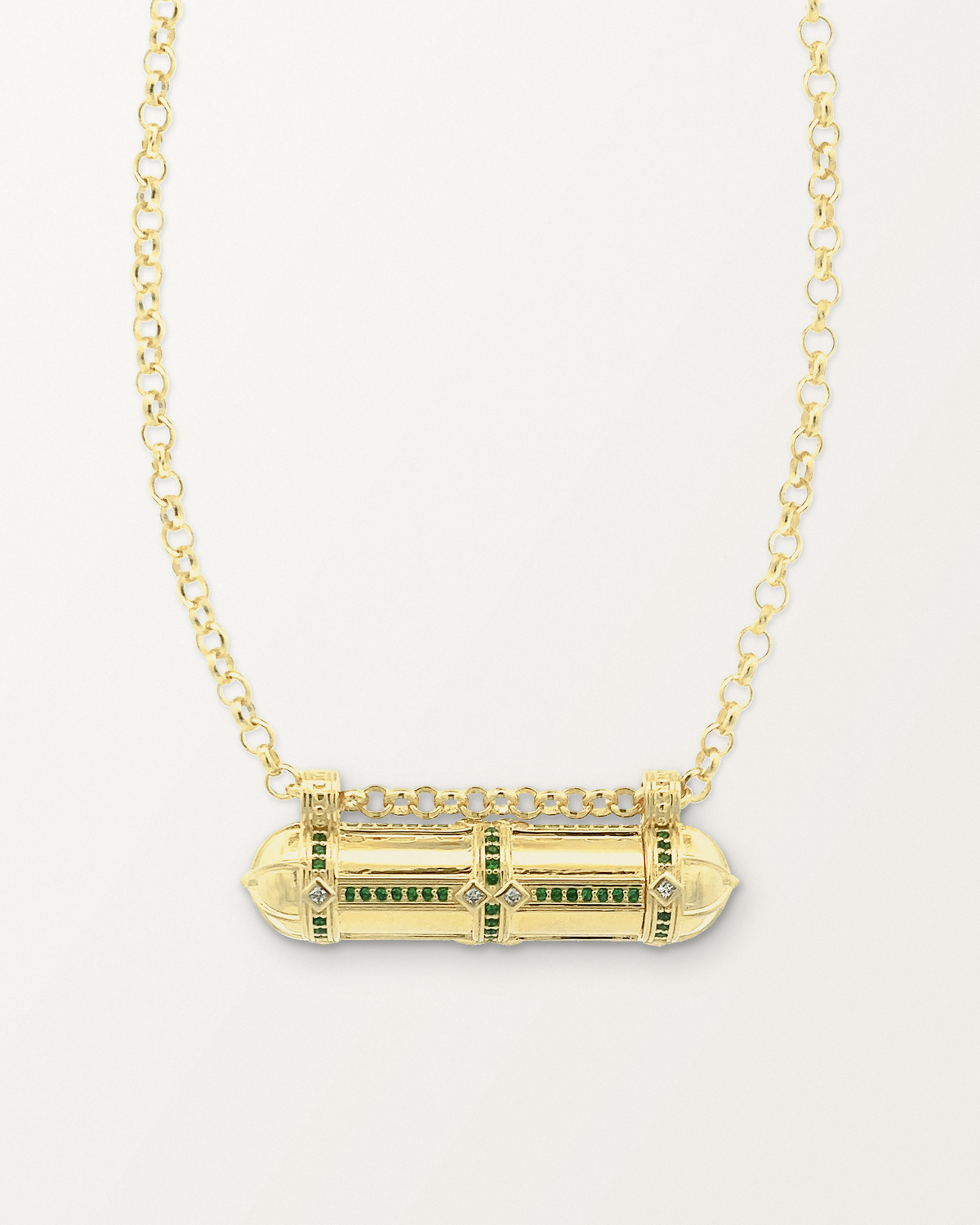 Afghani Tribal Emerald openable amulet necklace in 14K or 18K yellow gold, shown closed on a warm bone-white background.