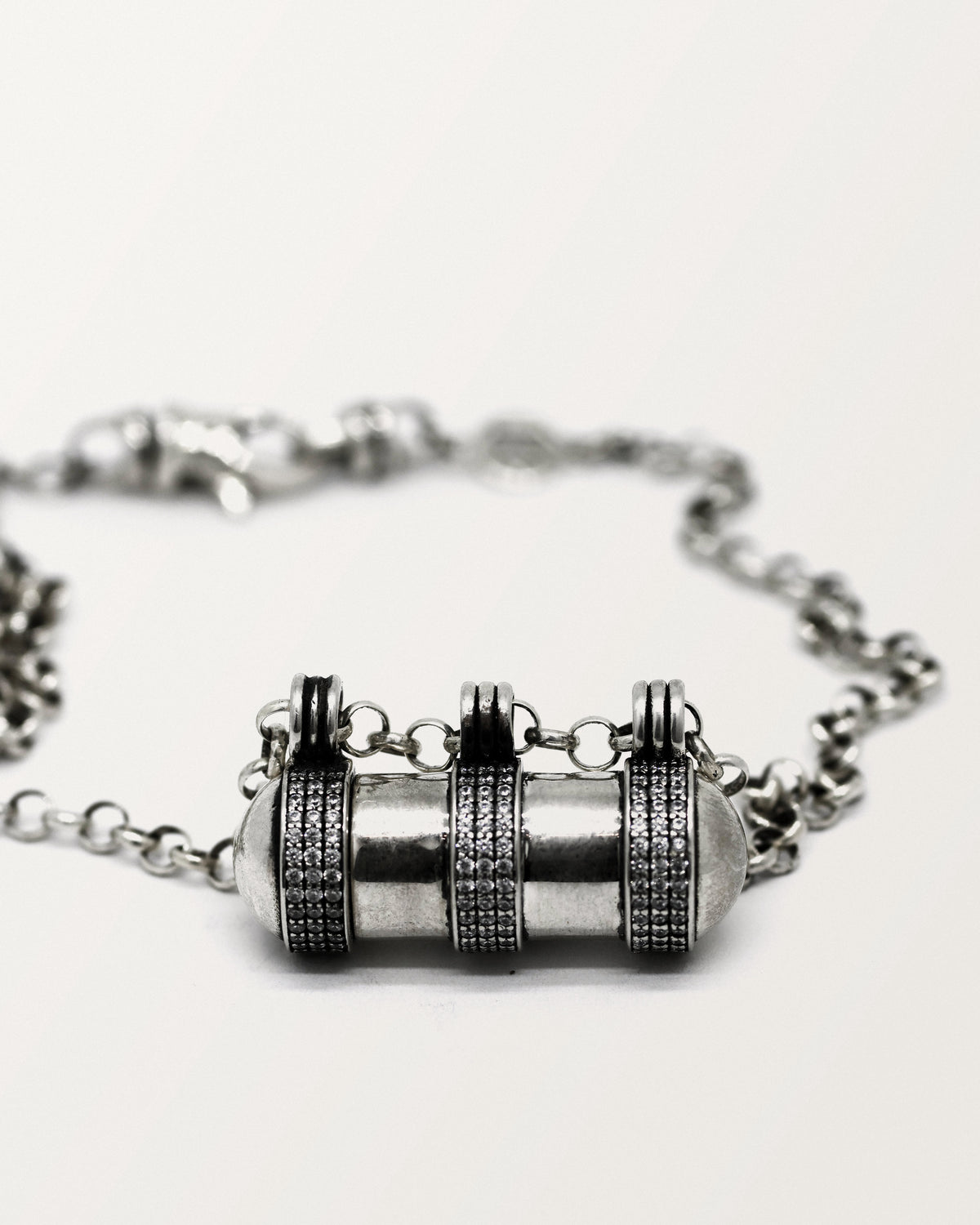 Agraja amulet necklace in sterling silver, closed, laid flat on white.