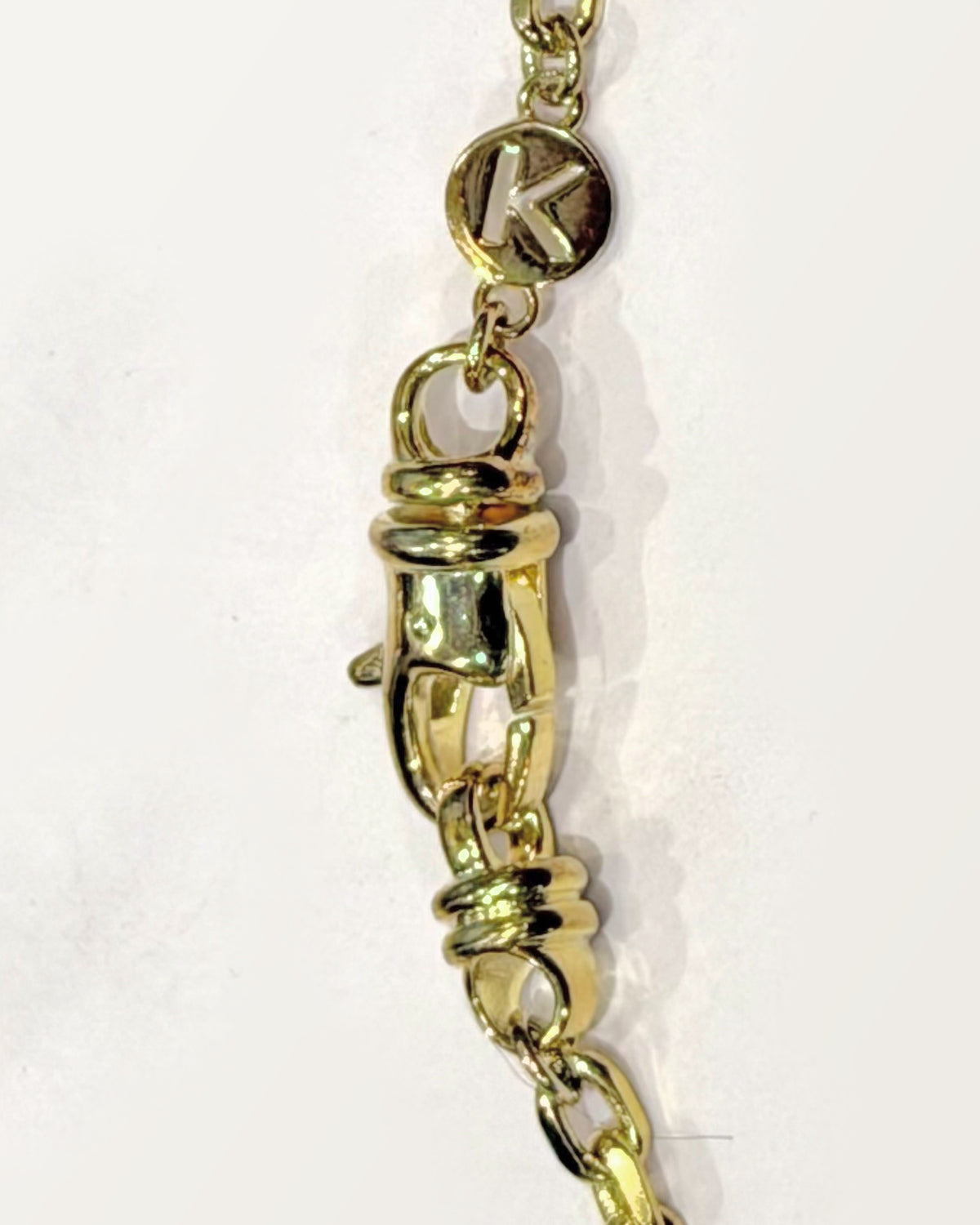 The Kavacha clasp with its branded K tag, in 14K or 18K yellow gold.