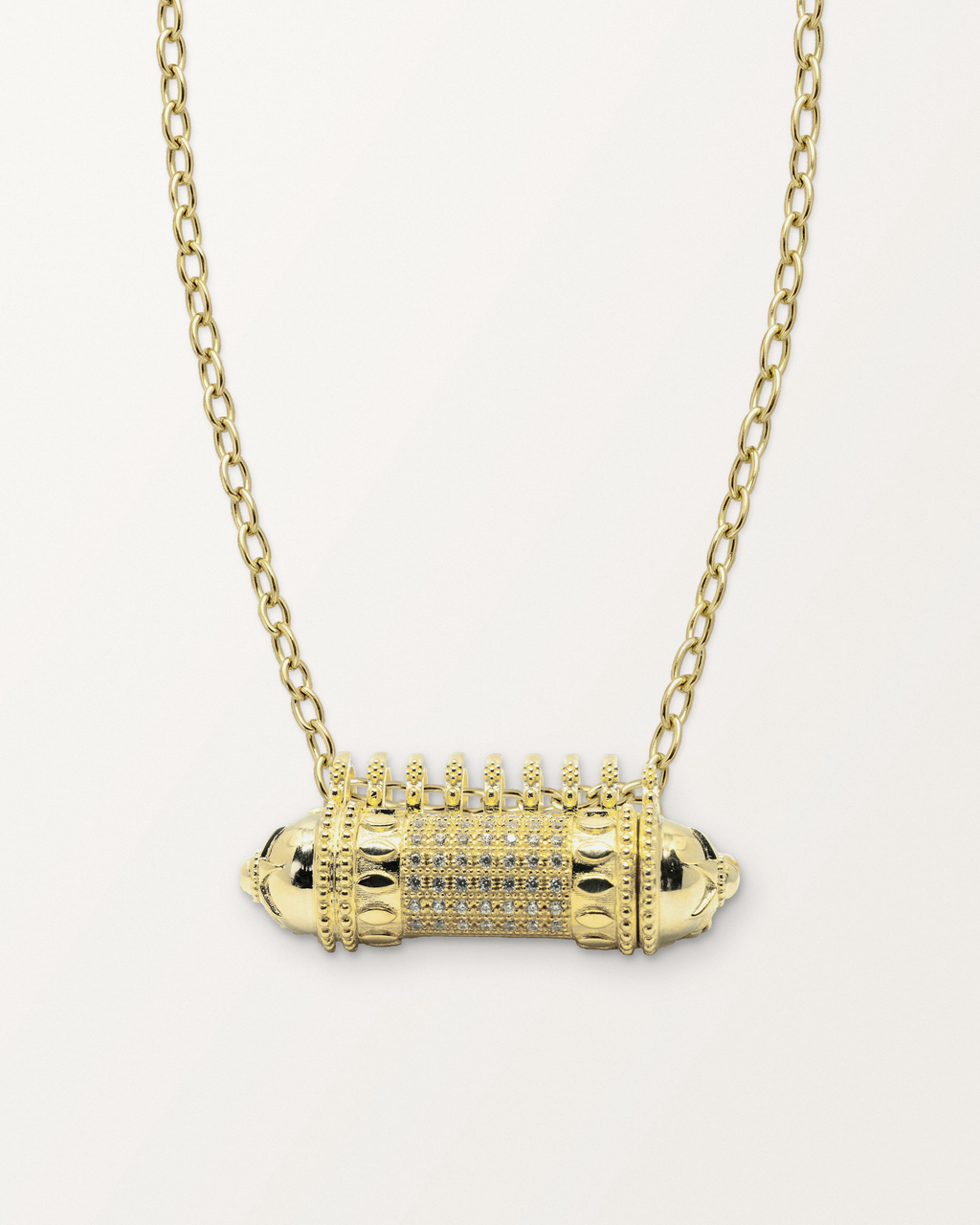 Antique Pave openable amulet necklace in 14K or 18K yellow gold, closed, on a warm bone-white background.