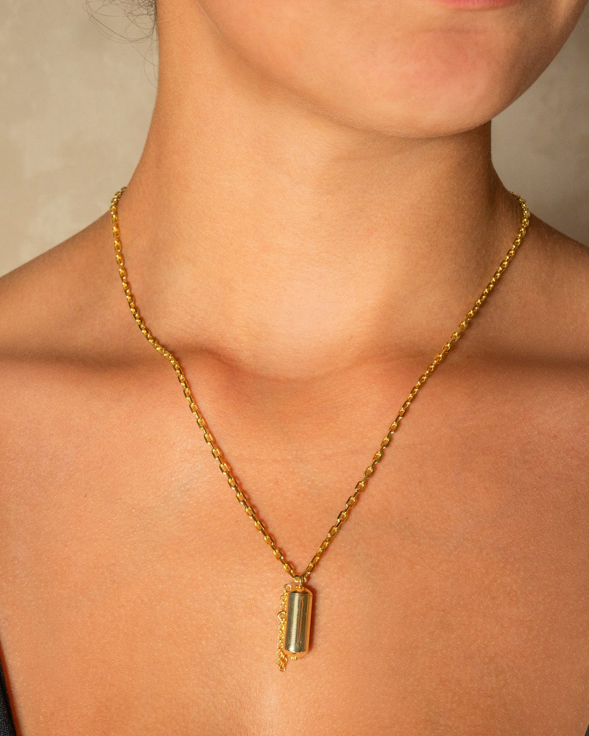 Capsule Small openable amulet necklace in 14K or 18K yellow gold, worn by a model.