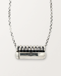 Sterling silver Kerala Large amulet necklace, closed, on a warm bone-white background, chain exiting the top of frame.