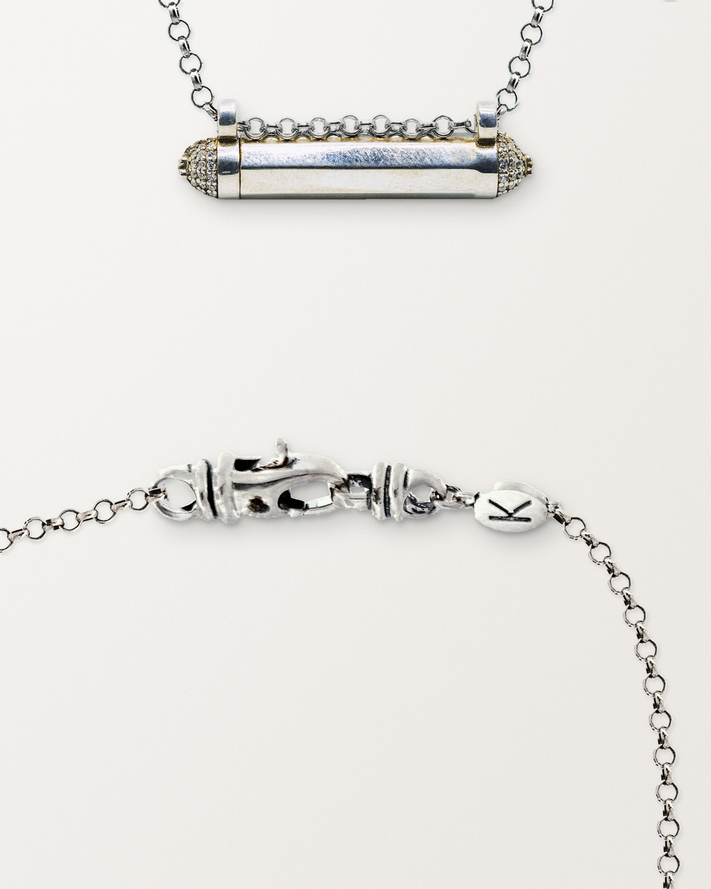 Sterling silver Kerala Pave amulet beside a close view of the lobster clasp and oval K tag on its chain.