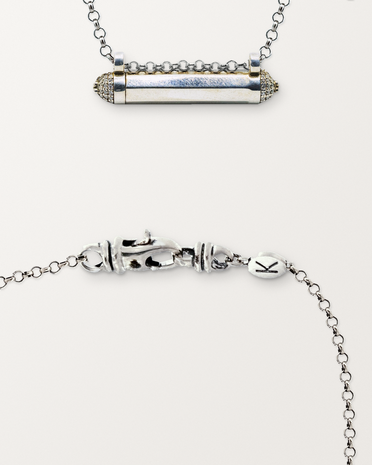 Sterling silver Kerala Pave amulet beside a close view of the lobster clasp and oval K tag on its chain.