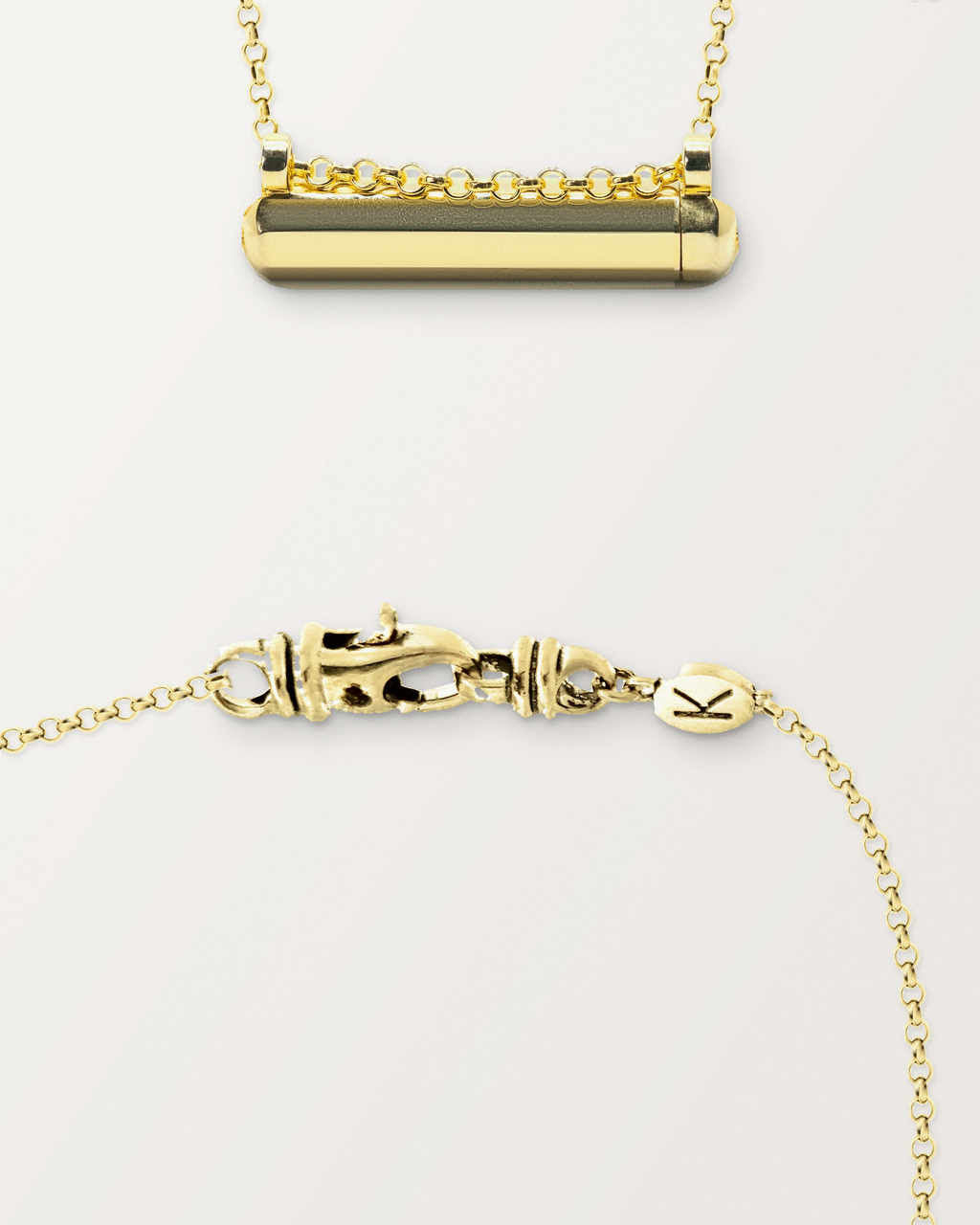 Kerala Small openable amulet necklace in 14K or 18K yellow gold, beside a close view of the lobster clasp and oval K tag on its chain.