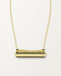 Kerala Small openable amulet necklace in 14K or 18K yellow gold, shown closed on a warm bone-white background.