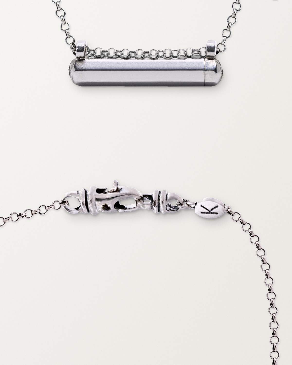 Sterling silver Kerala Small amulet beside a close view of the lobster clasp and oval K tag on its chain.