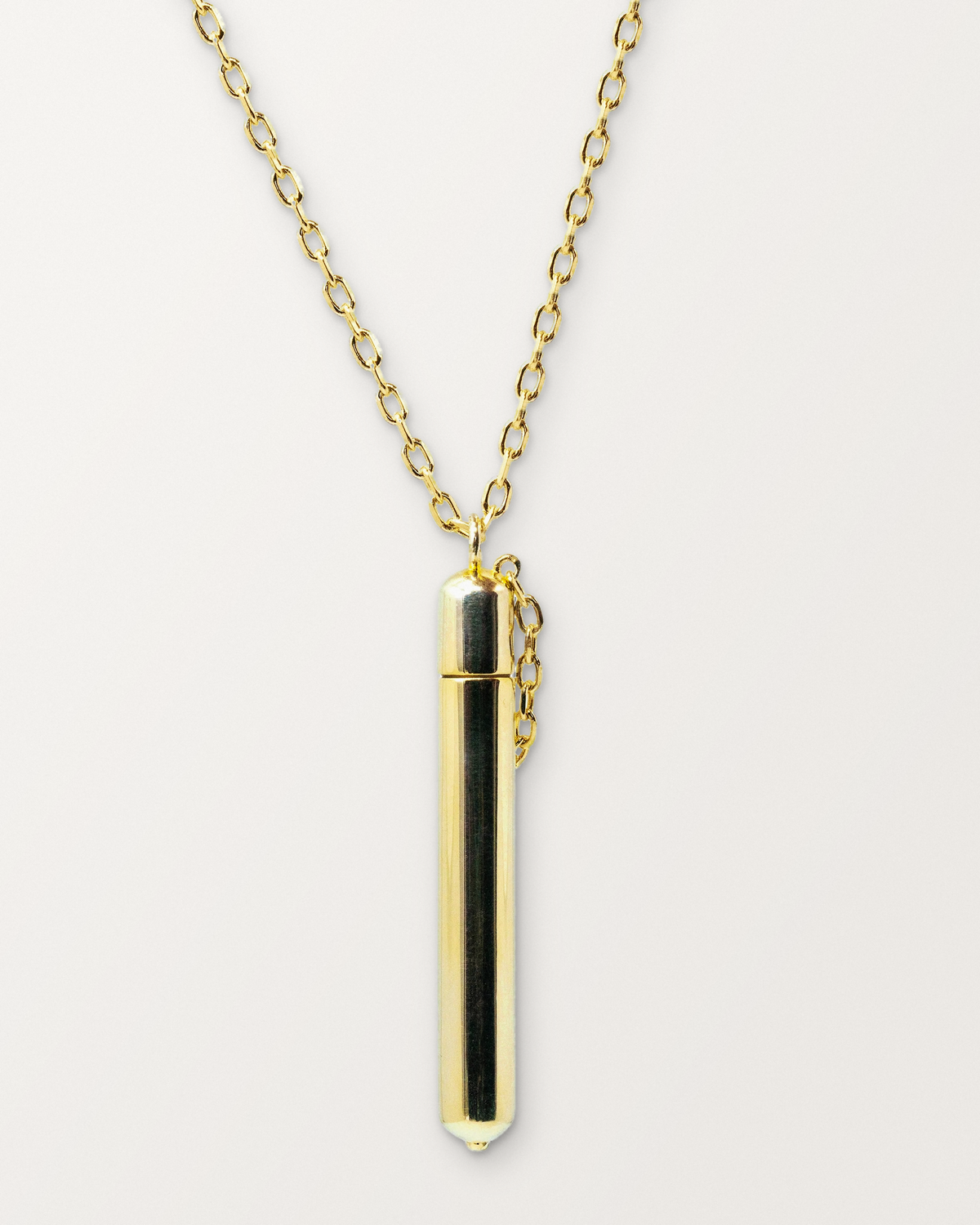 Moksha openable amulet necklace in 14K or 18K yellow gold, shown closed on a warm bone-white background.