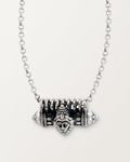 Sterling silver Narashimha amulet necklace, closed, on a warm bone-white background.