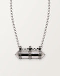 Sterling silver Pankaj amulet necklace, closed, on a warm bone-white background, chain exiting the top of frame.