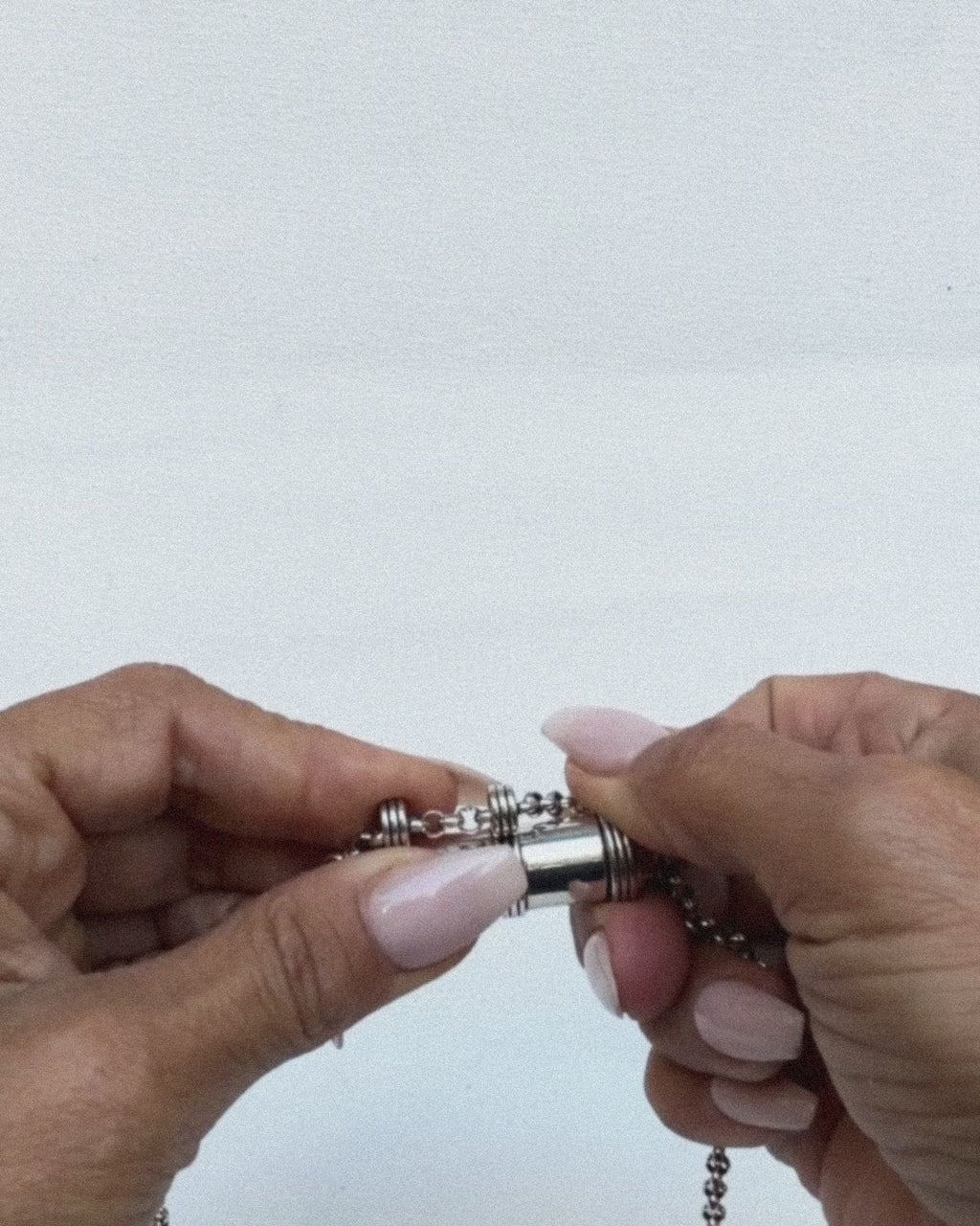 Jayashri's hands open and close the Pankaj amulet in sterling silver, showing the chamber.