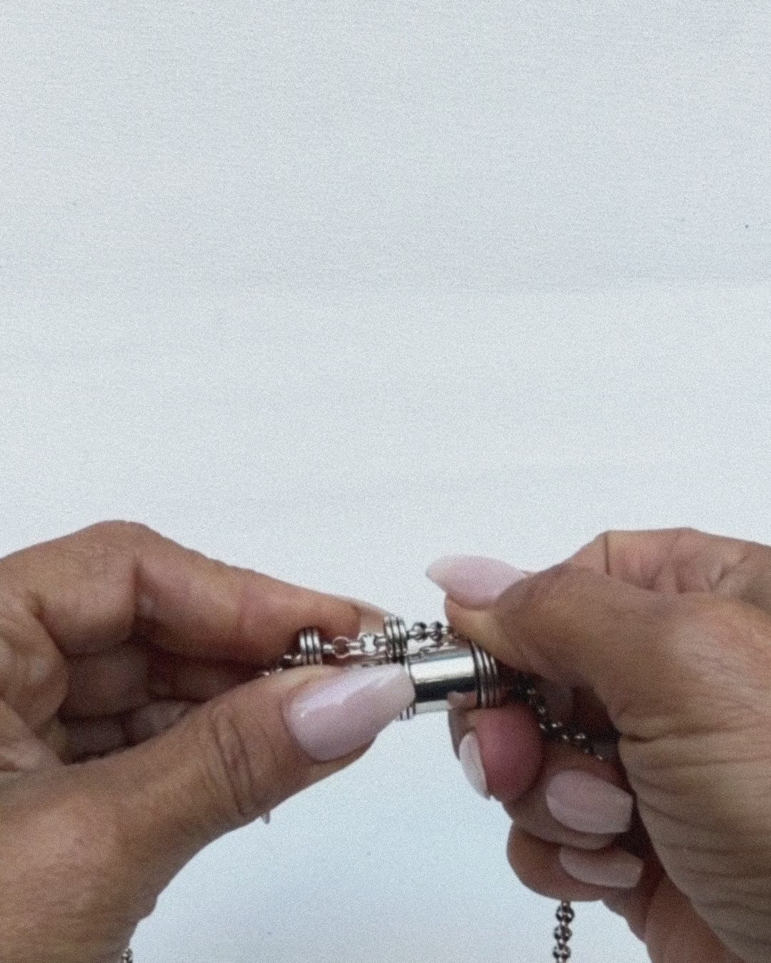 Jayashri's hands open and close the Pankaj amulet in sterling silver, showing the chamber.