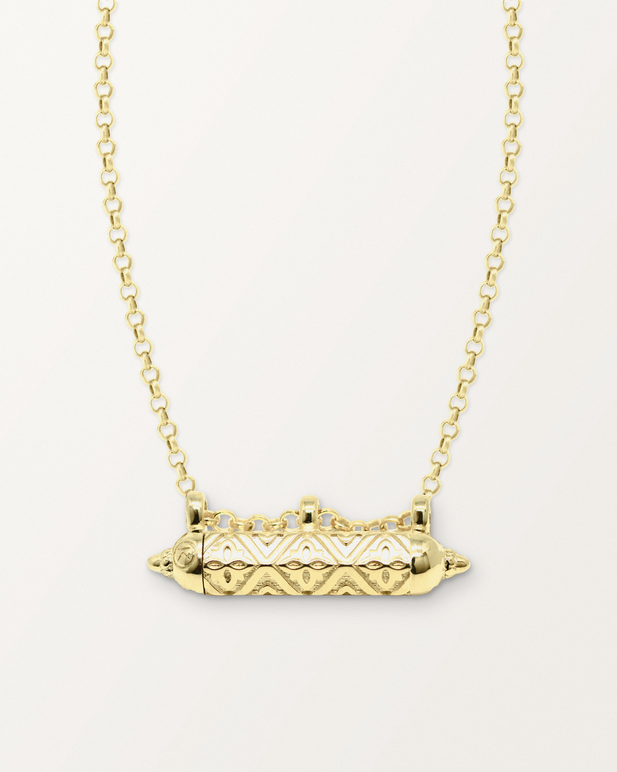 Shakti openable amulet necklace in 14K or 18K yellow gold, shown closed on a warm bone-white background.