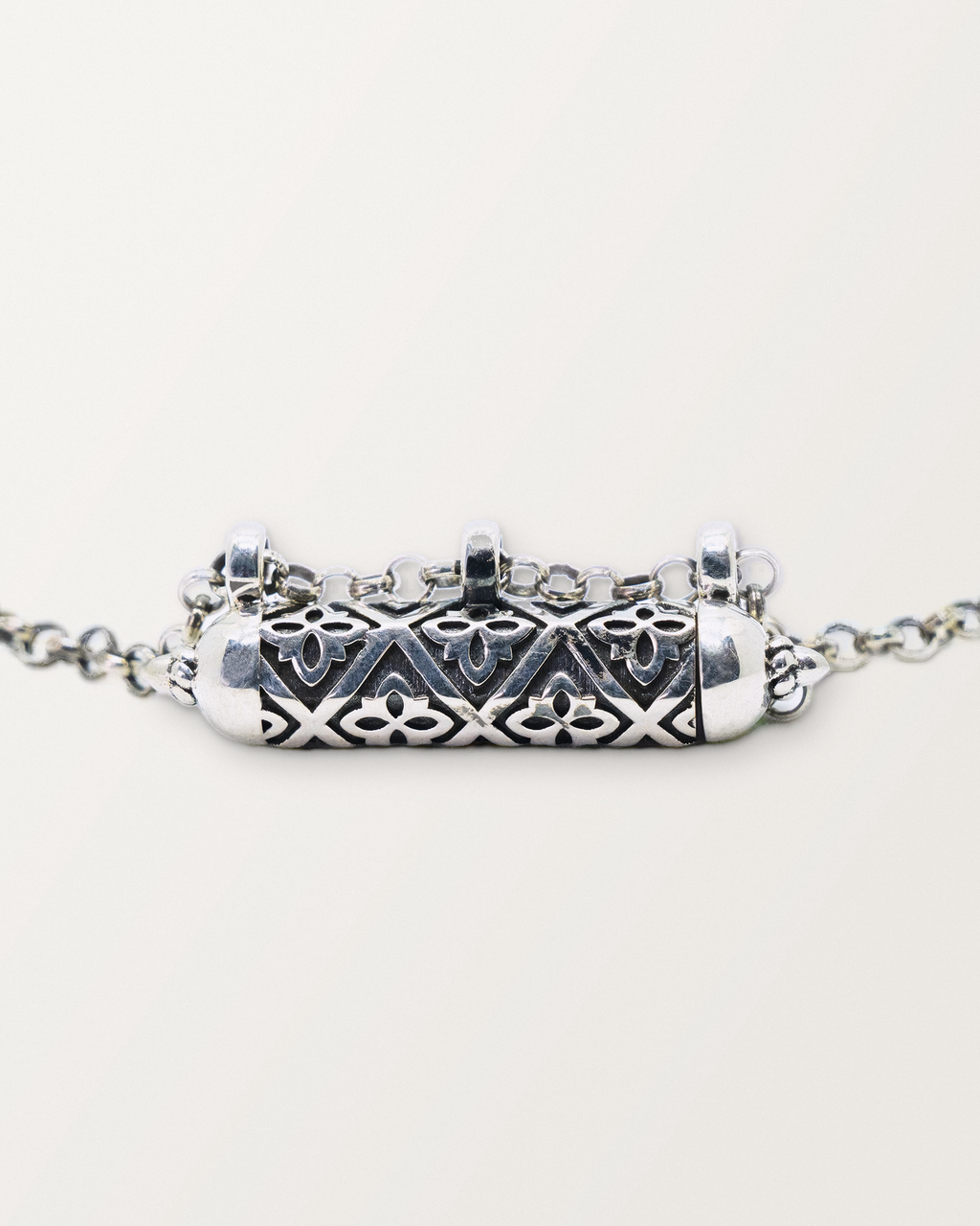 Close-up of the closed sterling silver Shakti amulet, showing the antiqued surface, pierced lattice, and edges.