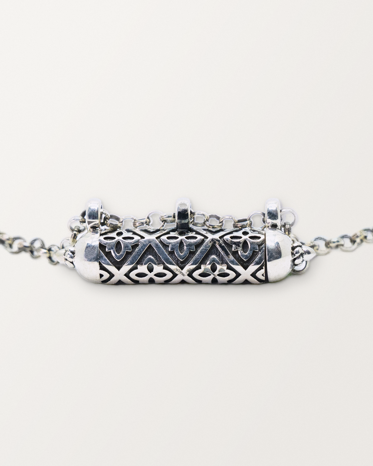 Close-up of the closed sterling silver Shakti amulet, showing the antiqued surface, pierced lattice, and edges.