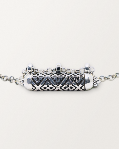 Close-up of the closed sterling silver Shakti amulet, showing the antiqued surface, pierced lattice, and edges.