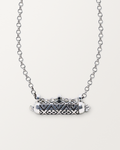 Sterling silver Shakti amulet necklace, closed, on a warm bone-white background, chain exiting the top of frame.