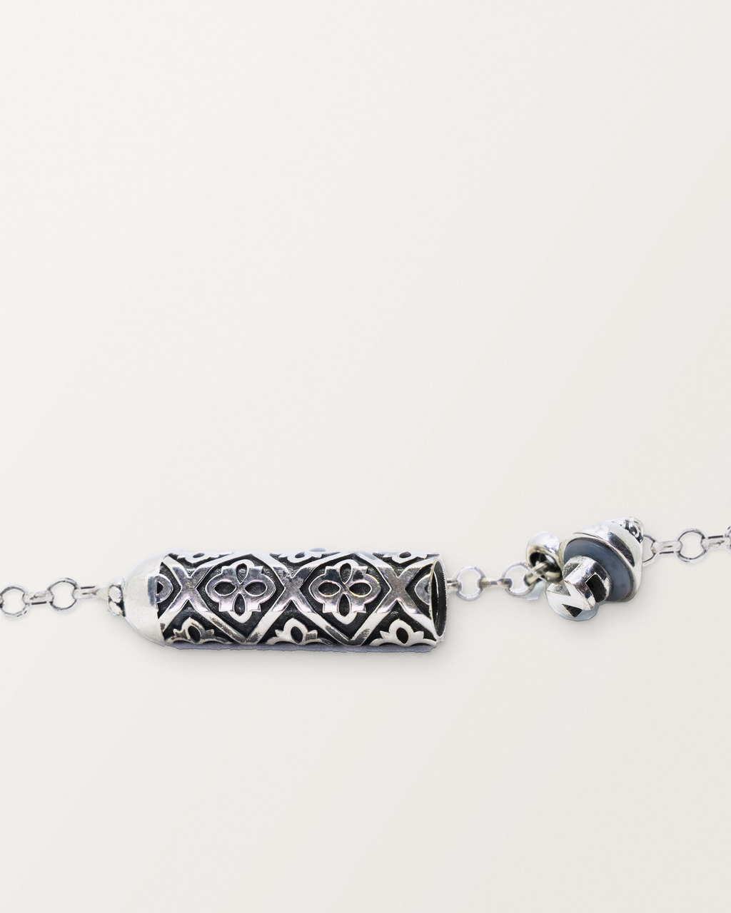 Sterling silver Shakti amulet open, showing the pierced lattice chamber, ribs, and cap mechanism.