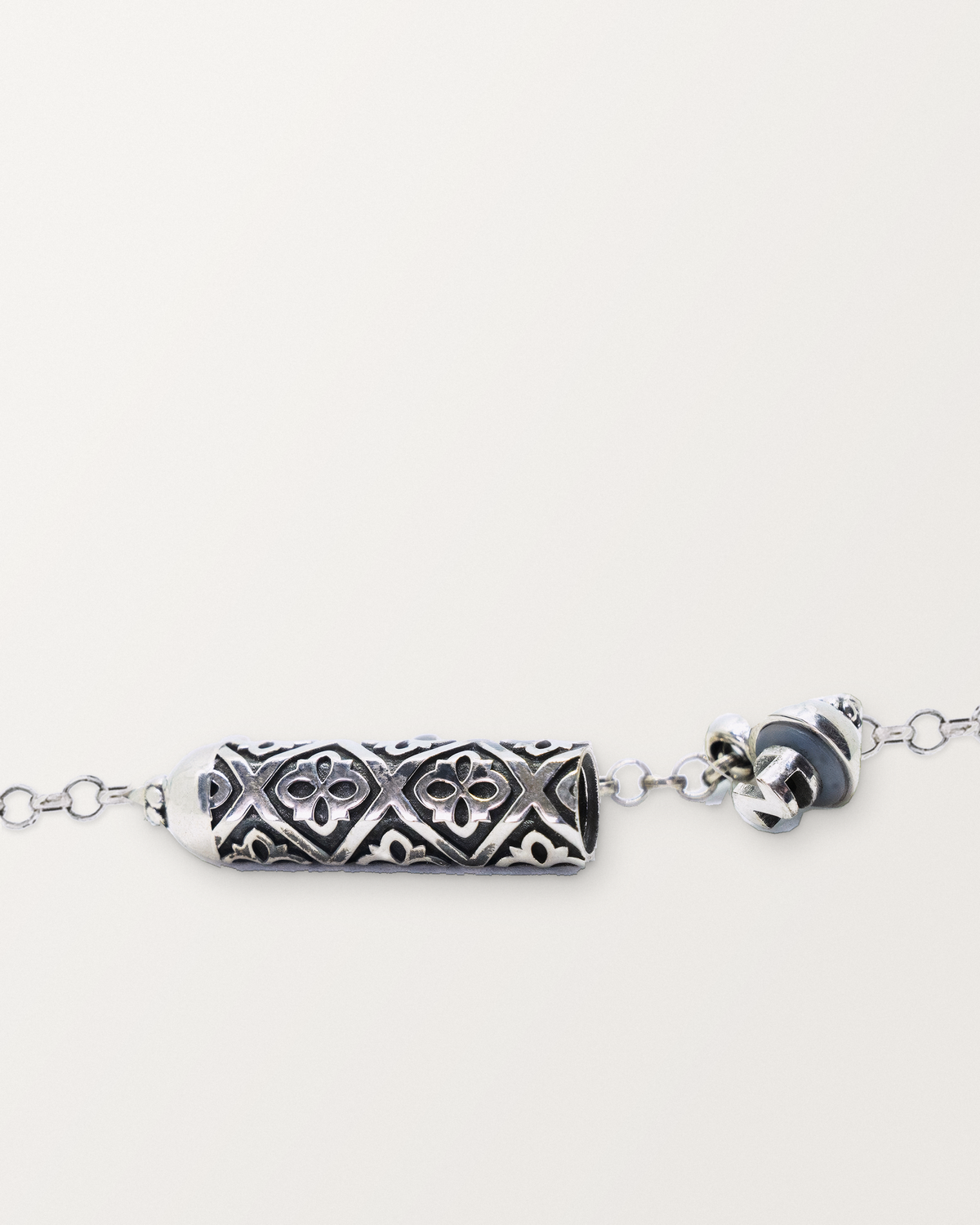 Sterling silver Shakti amulet open, showing the pierced lattice chamber, ribs, and cap mechanism.