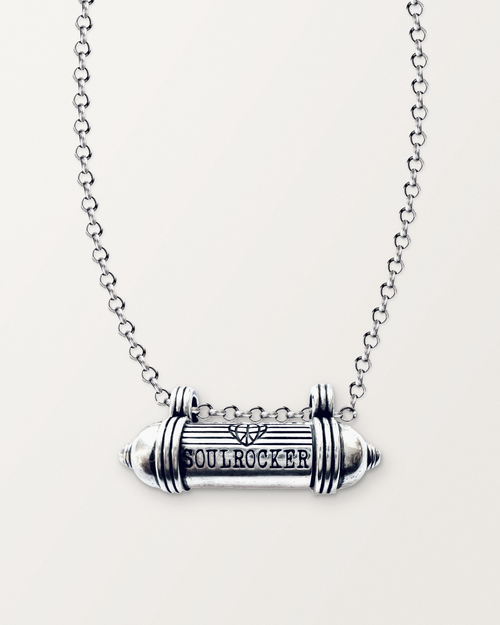 Sterling silver SOULROCKER amulet necklace, closed, engraved front, on its polished rolo chain against a warm bone-white background.