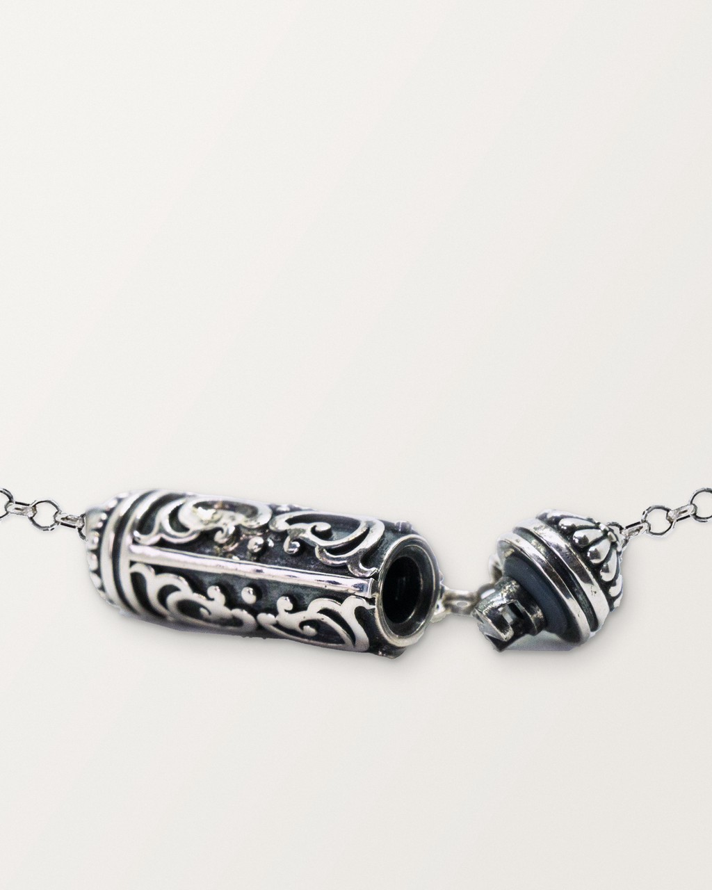 Sterling silver Sri amulet necklace open, showing the chamber opening, threaded plug, gasket and cap.