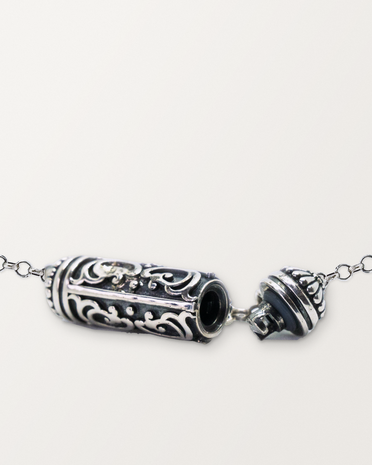 Sterling silver Sri amulet necklace open, showing the chamber opening, threaded plug, gasket and cap.