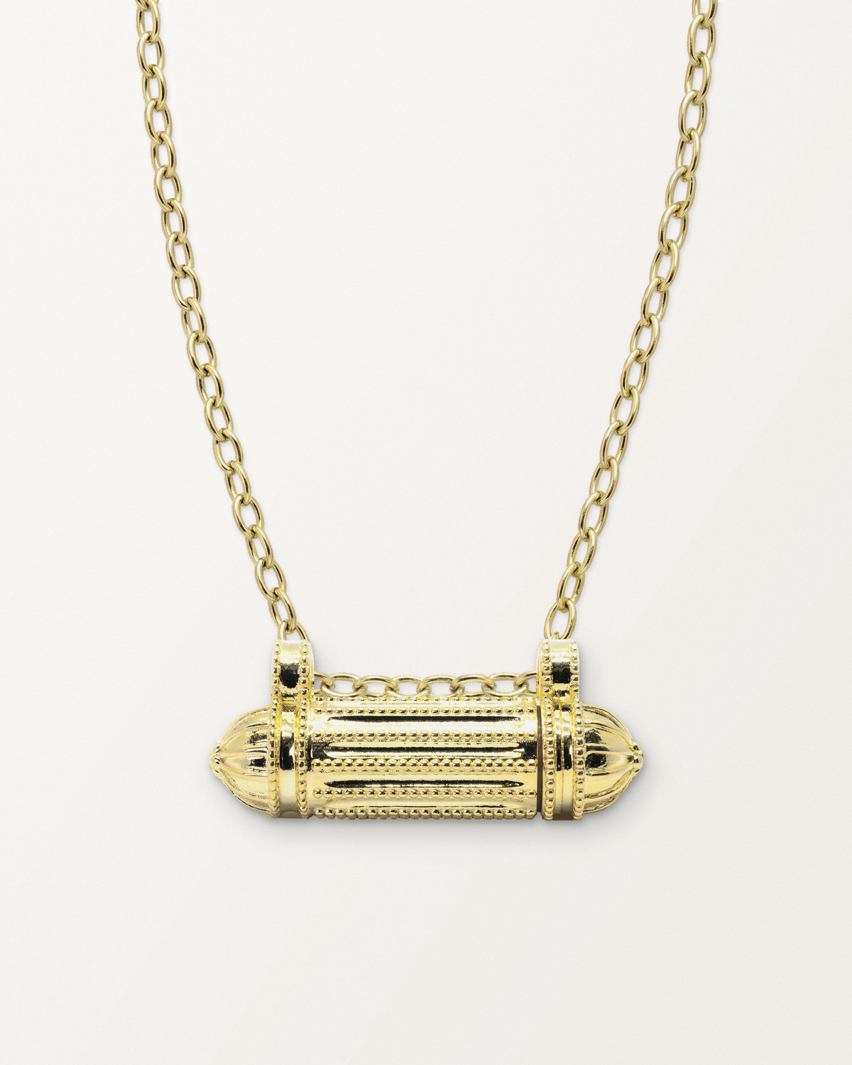 Taweez openable amulet necklace in 14K or 18K yellow gold, closed, on a warm bone-white background.