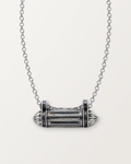 Sterling silver Taweez amulet necklace, closed, on a warm bone-white background, chain exiting the top of frame.