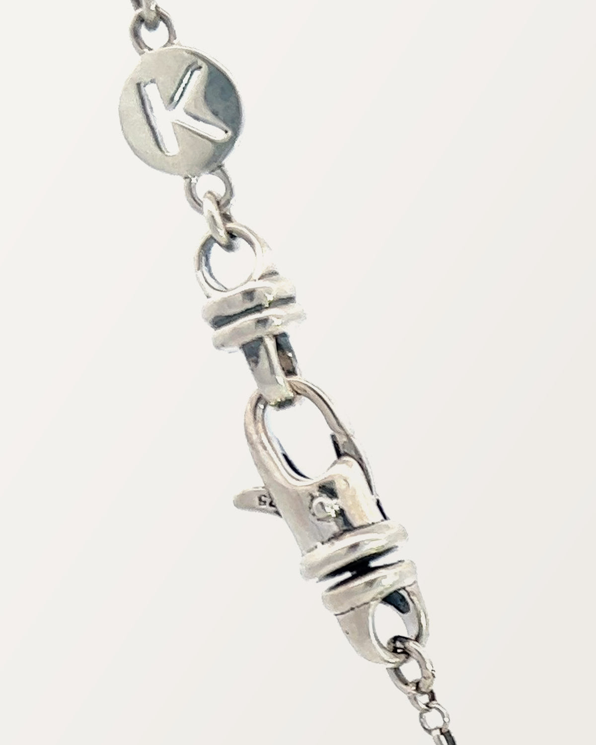 The small Kavacha clasp with its branded K tag, in sterling silver.