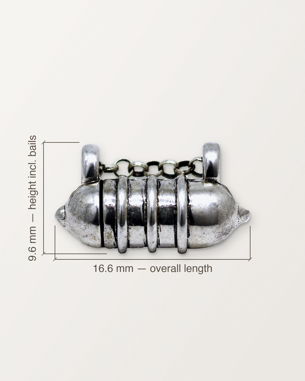 Sterling silver Vámana amulet with its measurements: 16.6 mm long and 9.6 mm high.