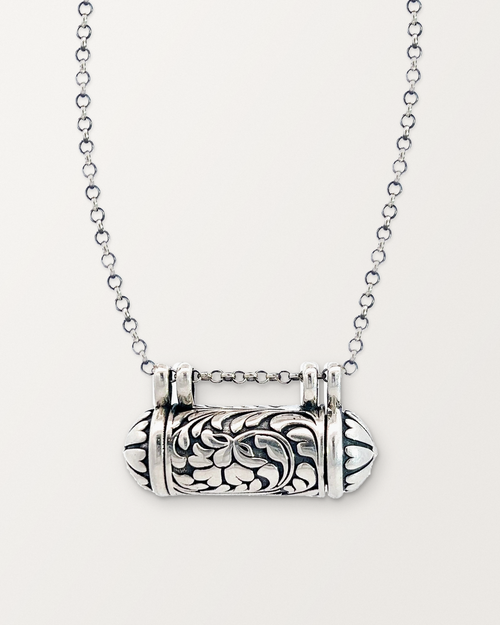 Sterling silver Vana amulet necklace, closed, on a warm bone-white background.