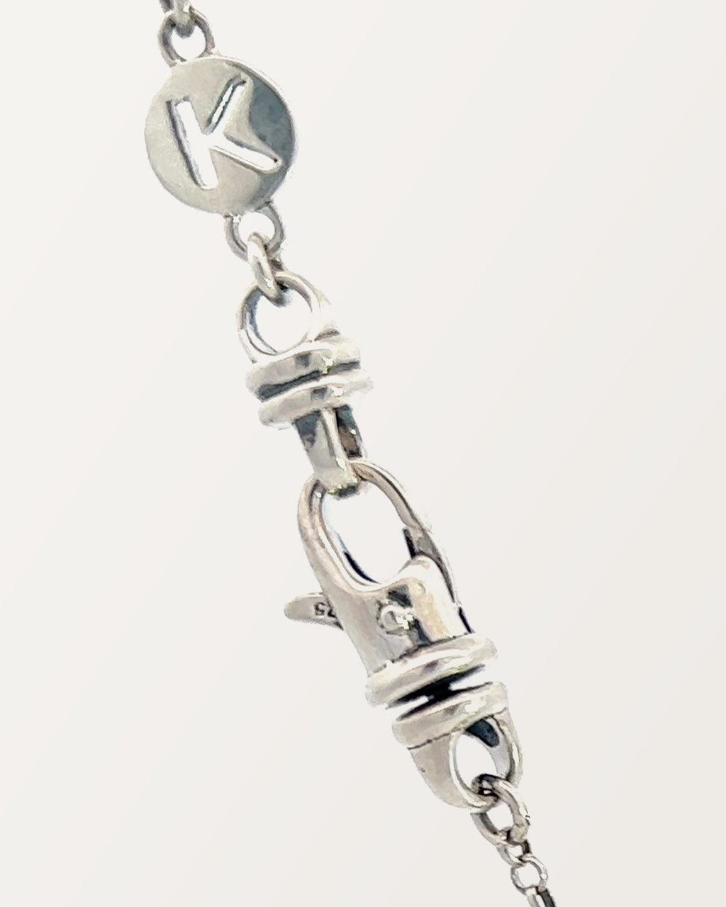 The small Kavacha clasp with its branded K tag, in sterling silver.