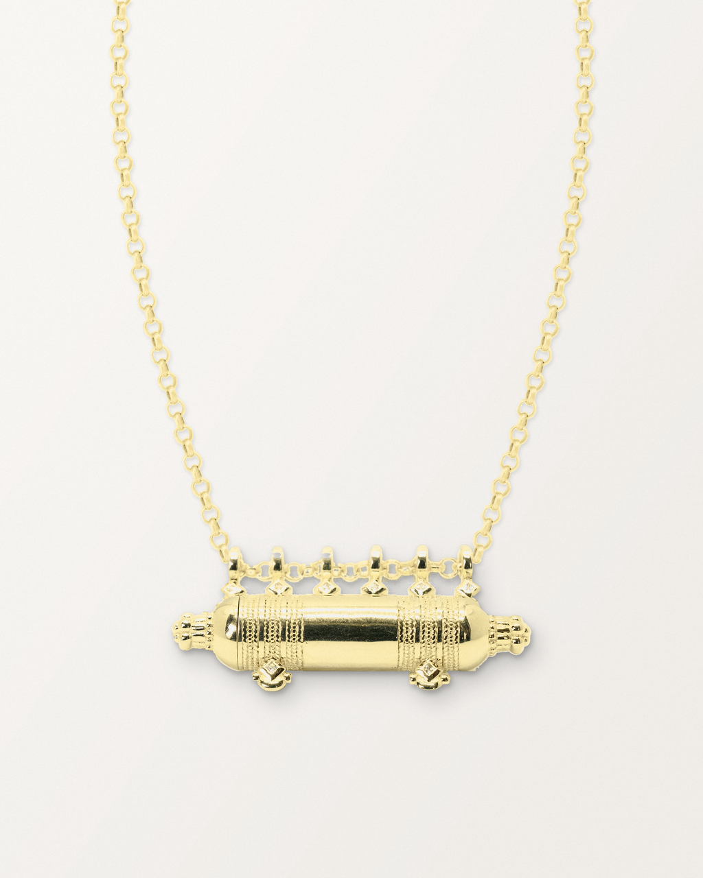 Yemen Wedding openable amulet necklace in 14K or 18K yellow gold, shown closed on a warm bone-white background.